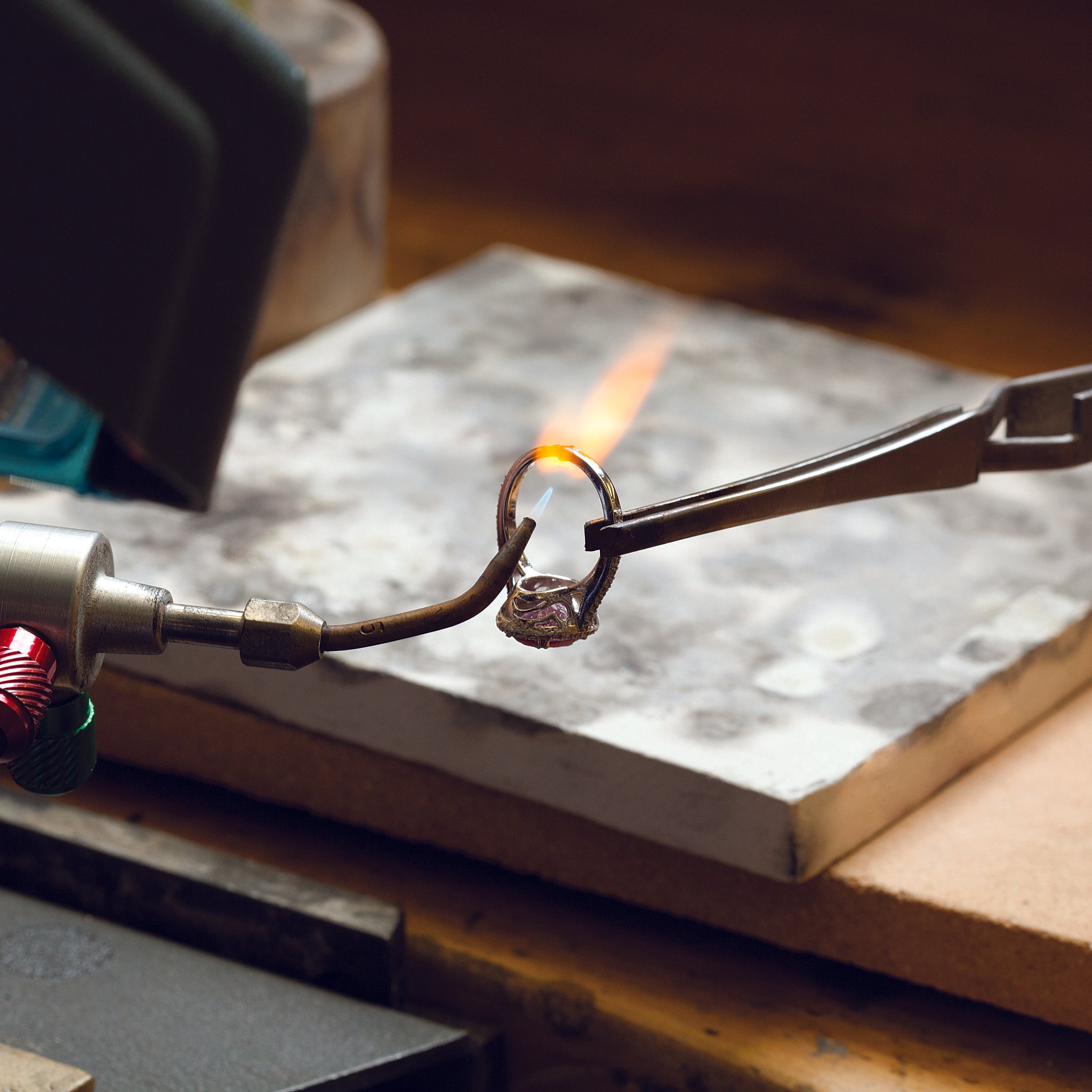 Person using a torch to work on a ring with a flame visible