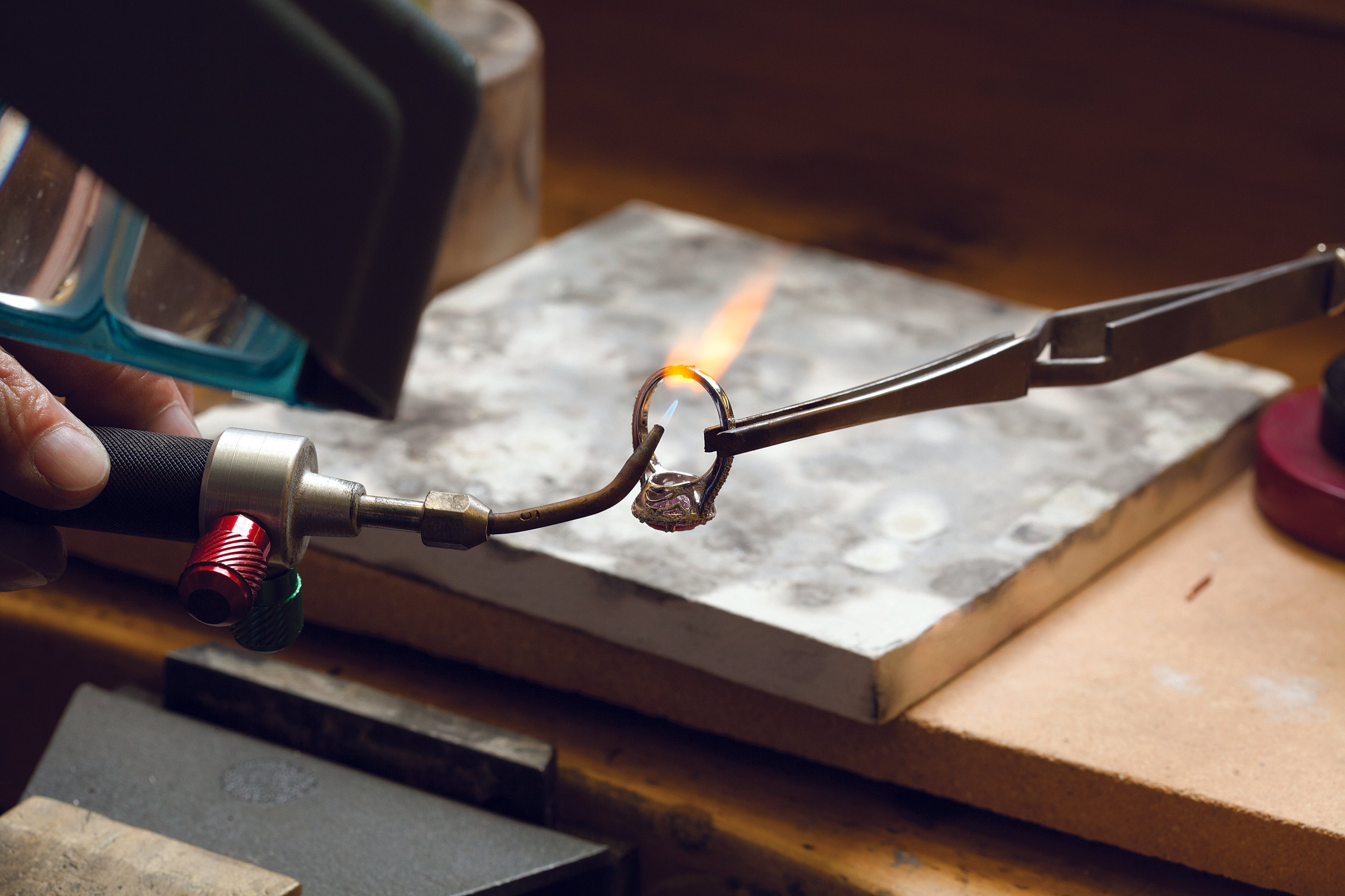 Person using a torch to work on a ring with a flame visible