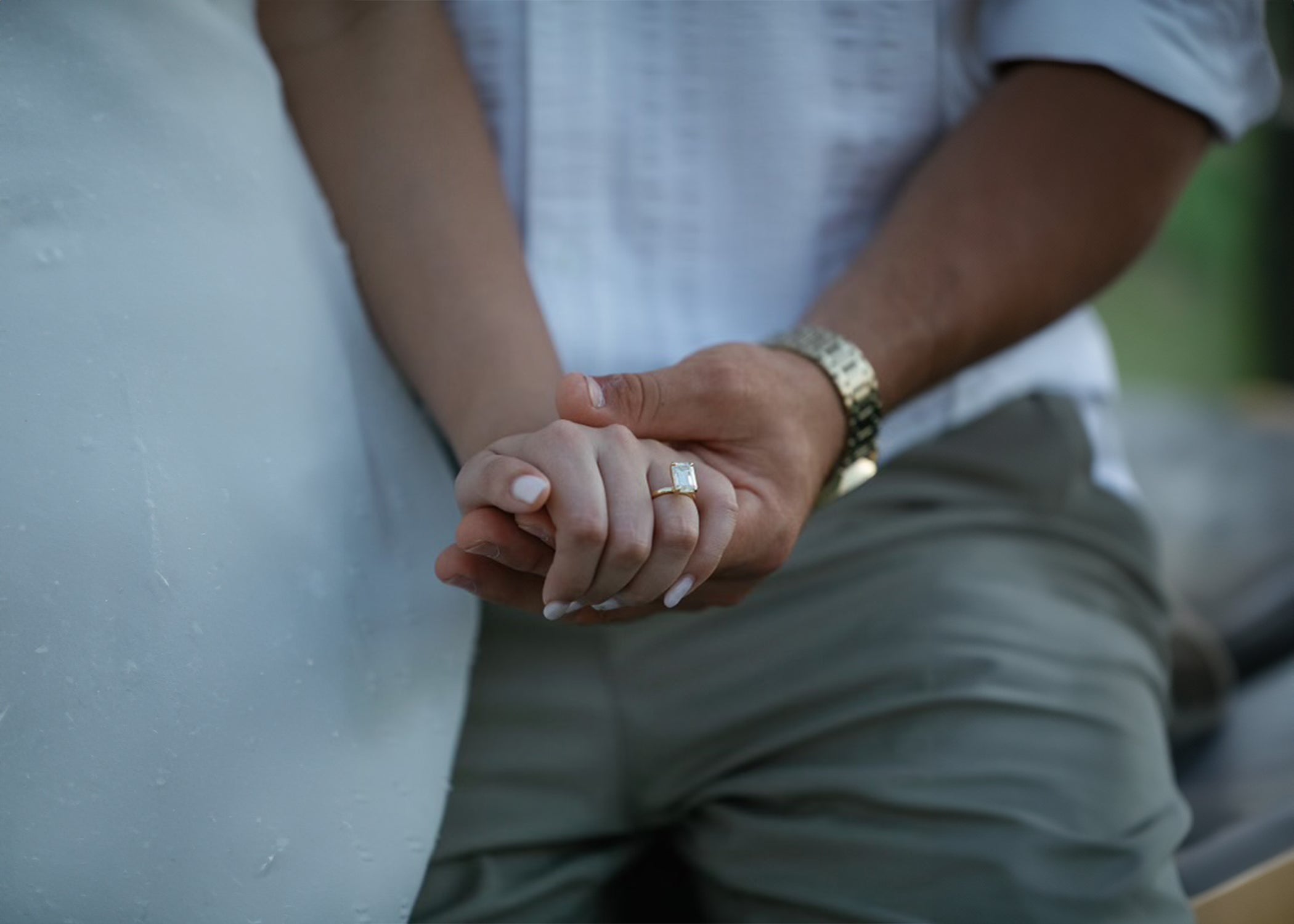 Two people holding hands with a blurred background