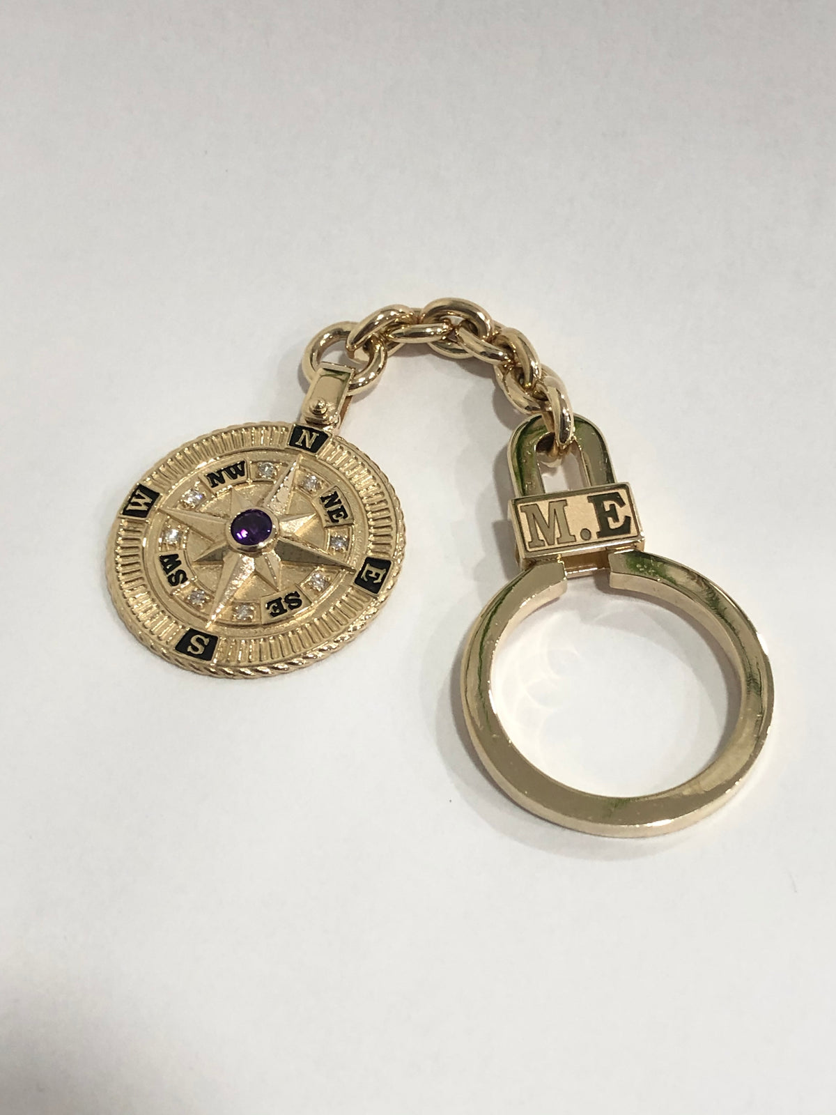 Gold compass keychain on a white background