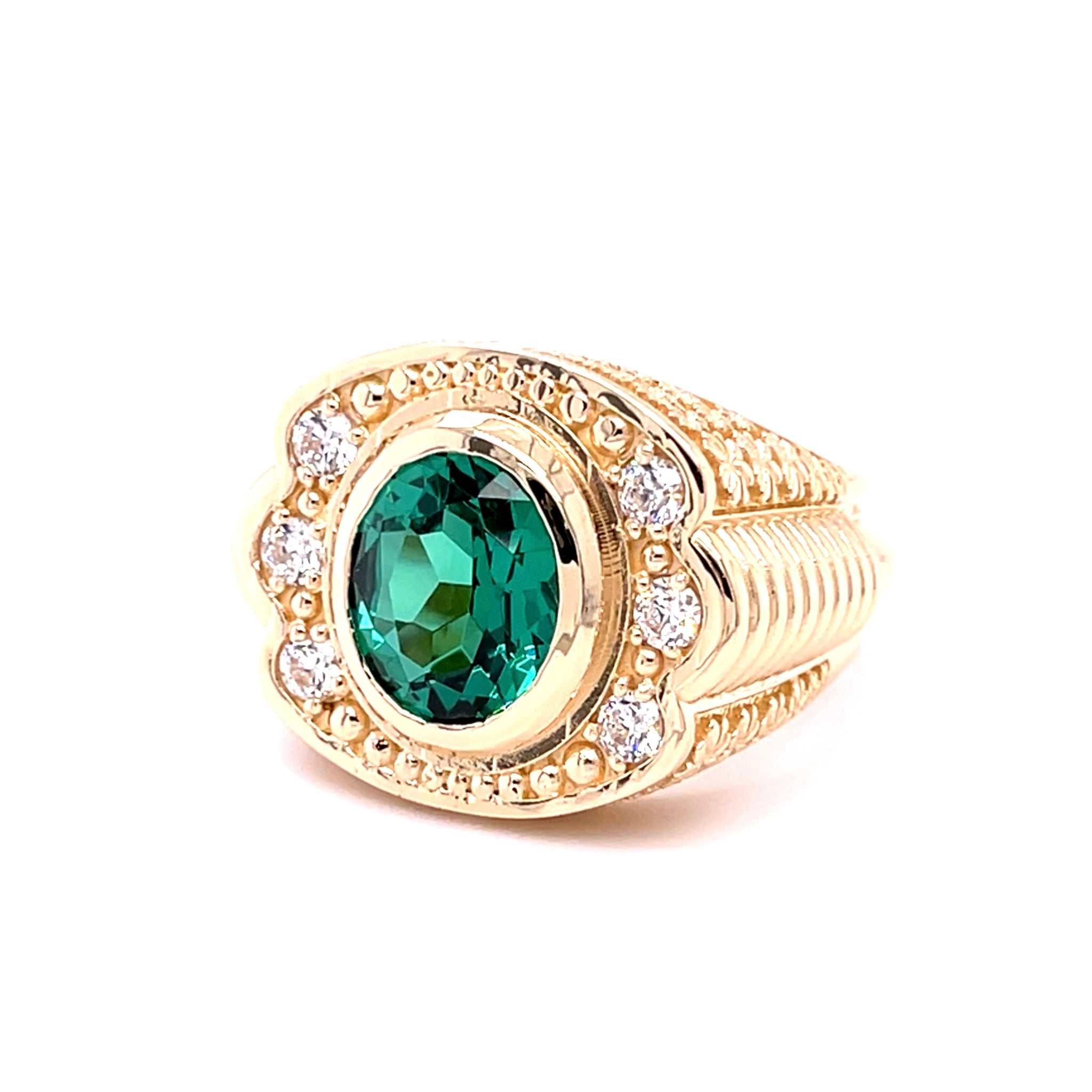 Gold ring with a green gemstone on a white background