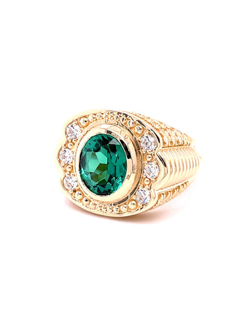 Gold ring with a green gemstone on a white background