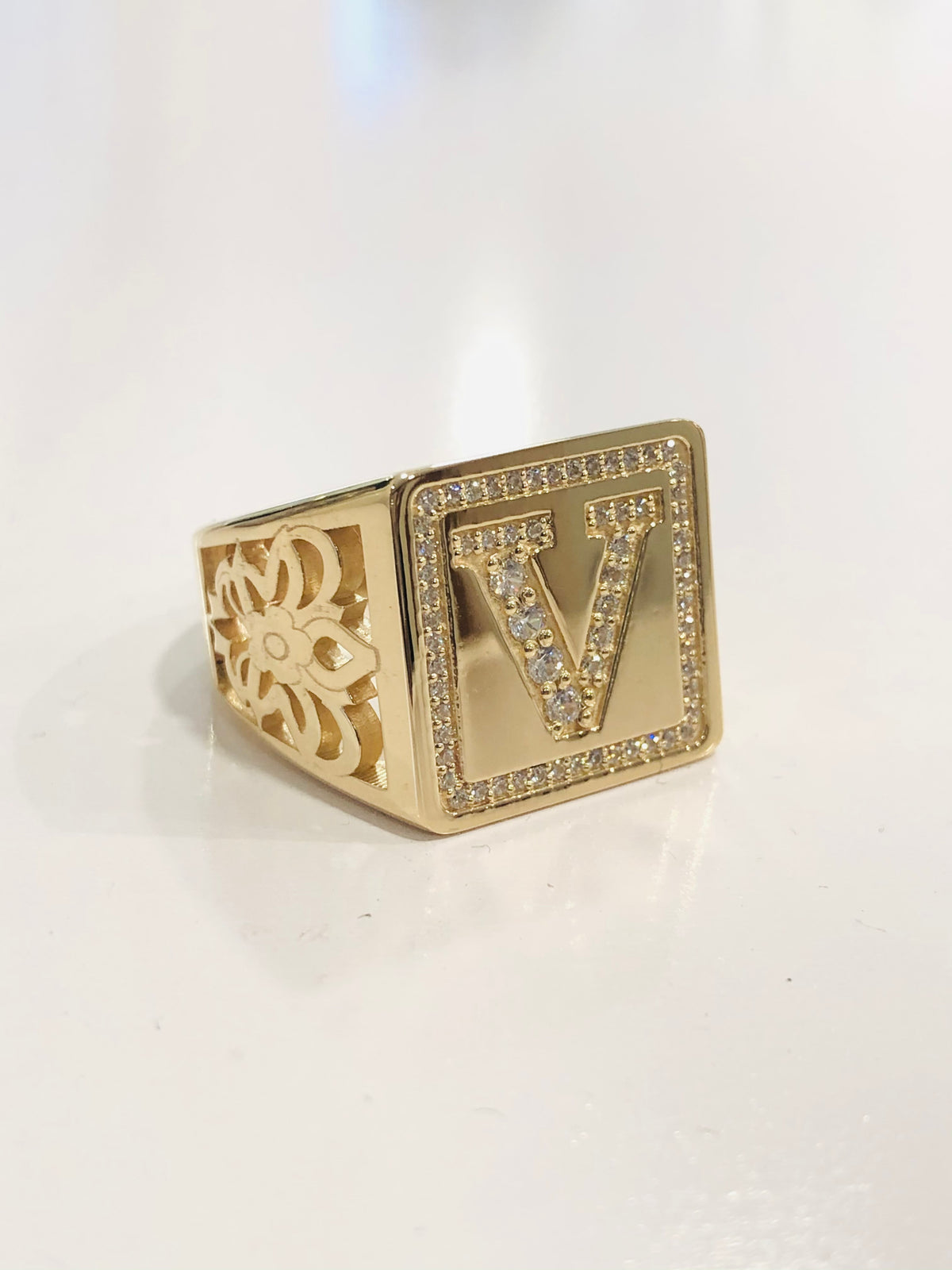 Gold ring with decorative design on a white background