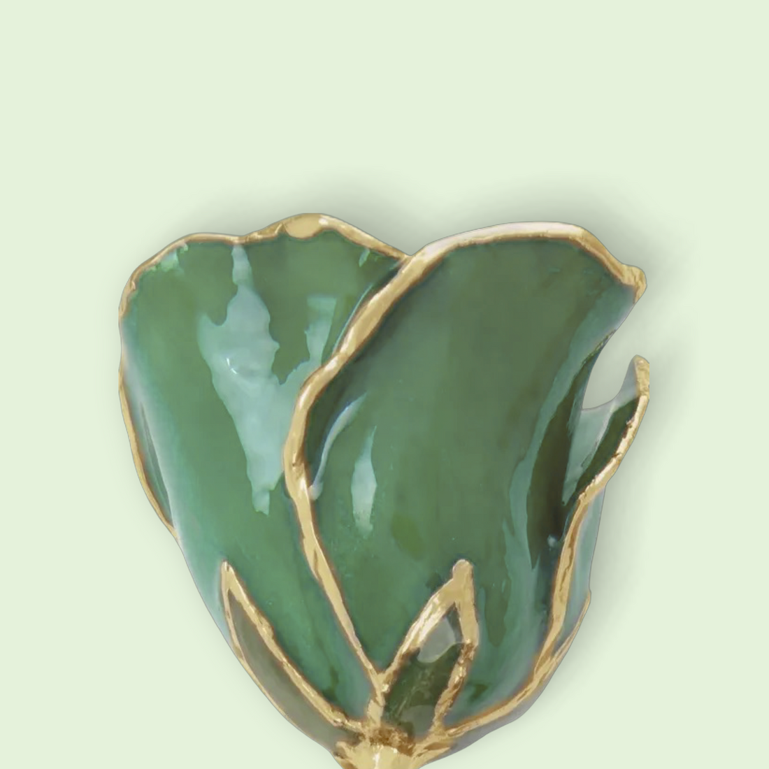 Green ceramic heart-shaped vase with gold trim on a light green background