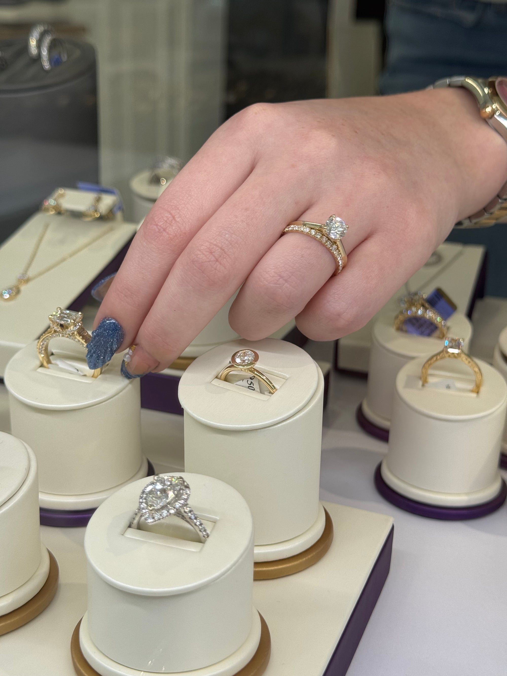 Hand selecting a ring from a display of jewelry