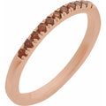 Rose gold ring with embedded brown gemstones on a white background