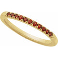 Gold ring with red gemstones on a white background