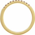 Gold ring with embedded red stones on a white background