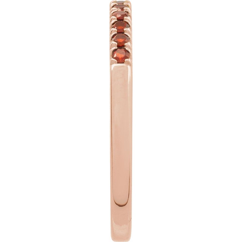 Rose gold ring with embedded gemstones on a white background