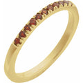 Gold ring with red gemstones on a white background