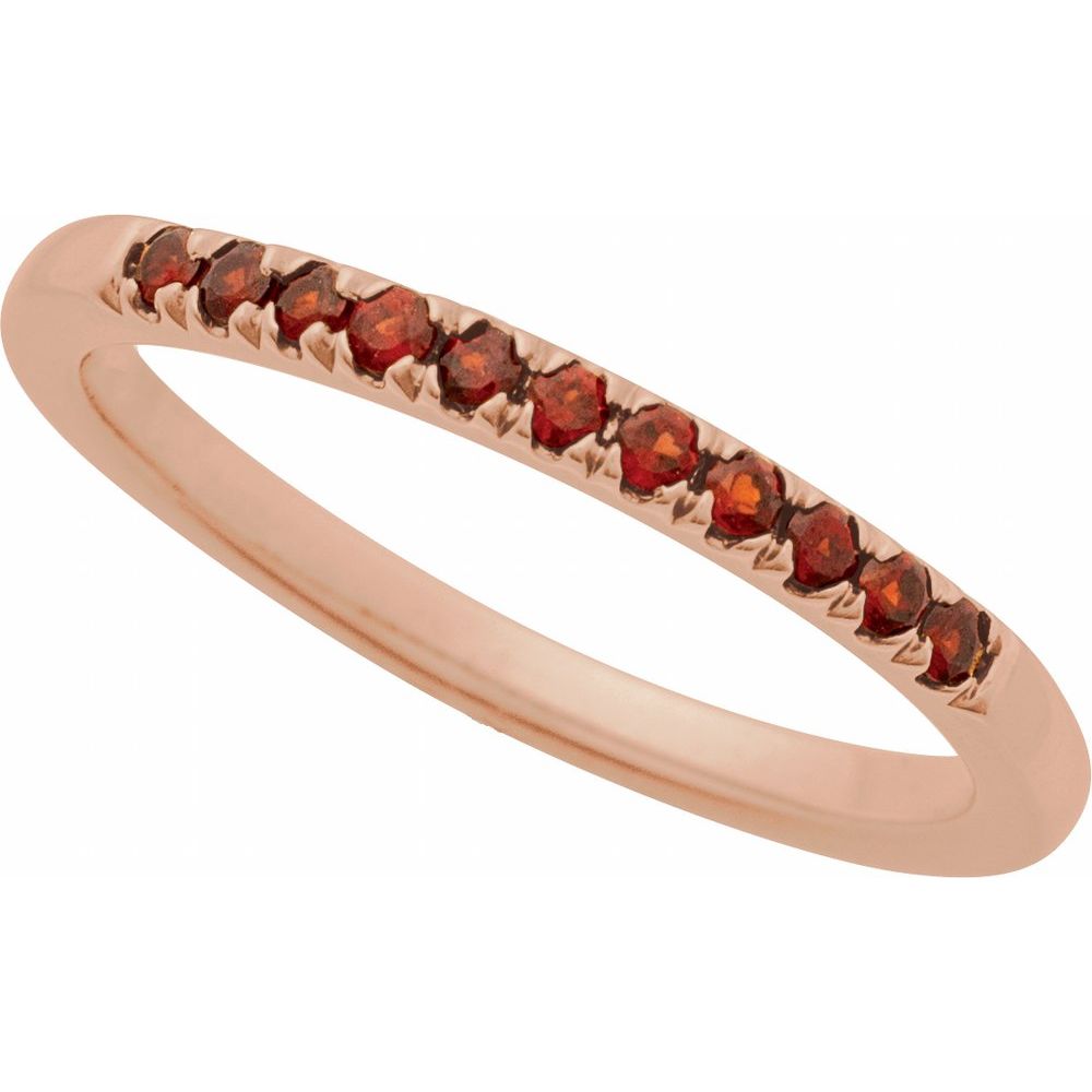 Rose gold ring with red gemstones on a white background