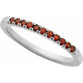 Silver ring with red gemstones on a white background