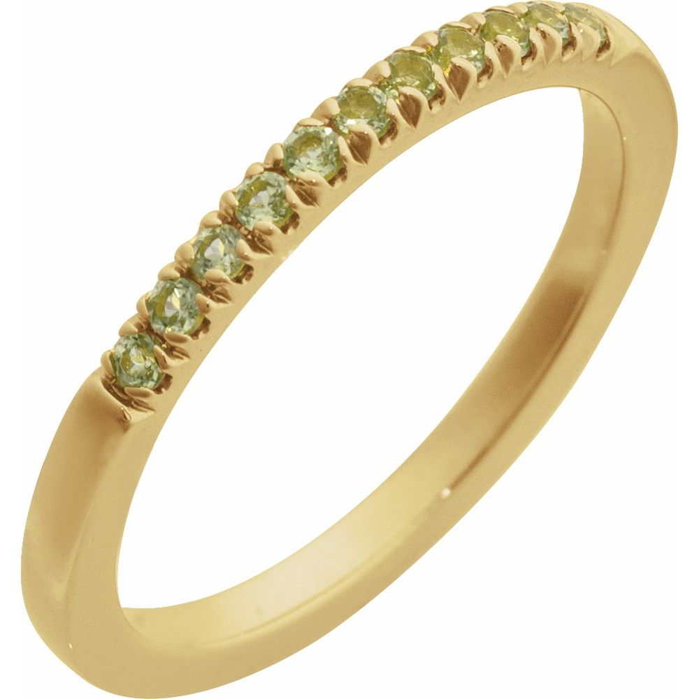 Gold ring with green gemstones on a light gray background, labeled 'August Peridot'.