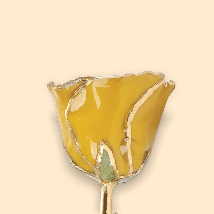 Decorative hairpin with gold top and green leaves on a beige background