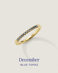 Gold ring with blue gemstones on a light gray background, labeled 'December Blue Topaz'.
