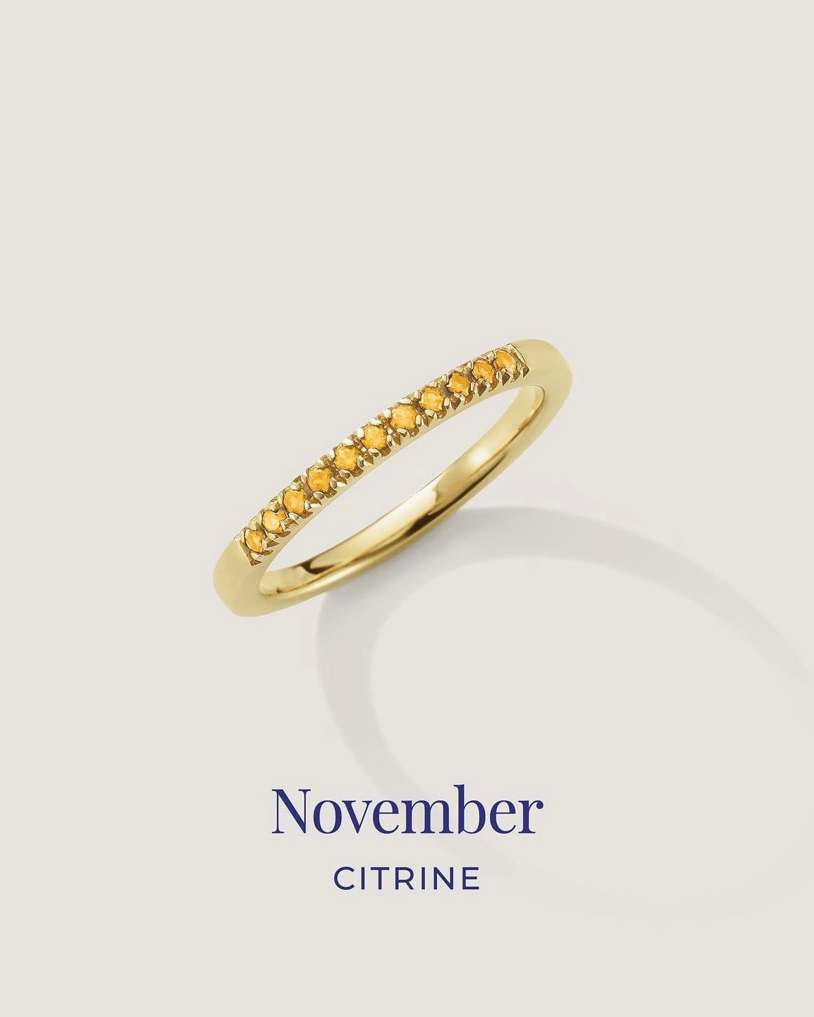 Gold ring with citrine stones on a light gray background, labeled 'November Citrine'.