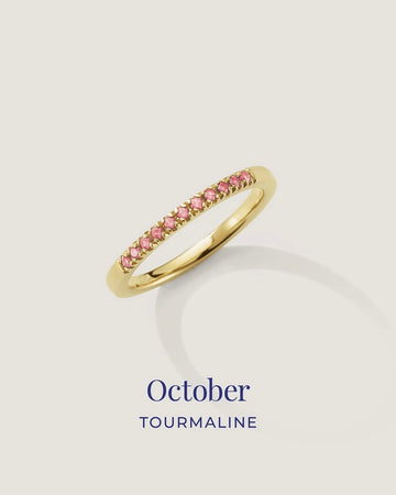 Gold ring with pink gemstones on a light gray background, labeled 'October Tourmaline'.