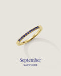 Gold ring with blue gemstones on a light gray background, labeled 'September Sapphire'.